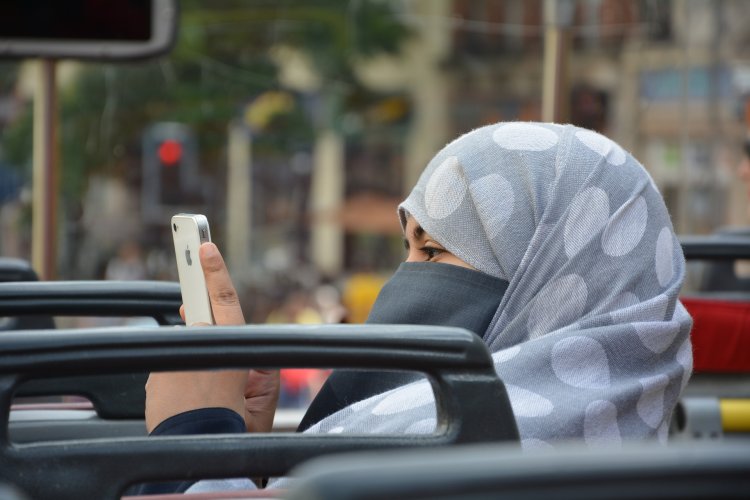 Muslim woman using her iphone